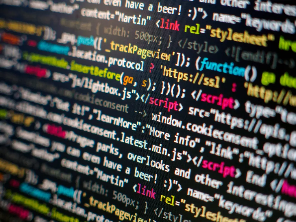 Close-up of colourful HTML and JavaScript source code on a dark computer screen