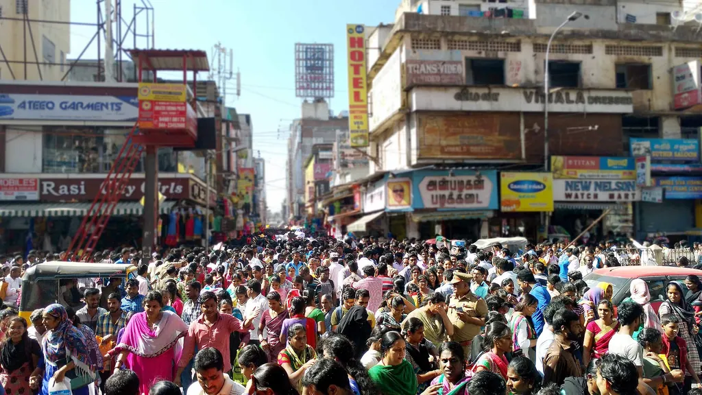 A crowded shopping street in T. Nagar, Chennai, lined with shop signboards for garments, watches and a hotel