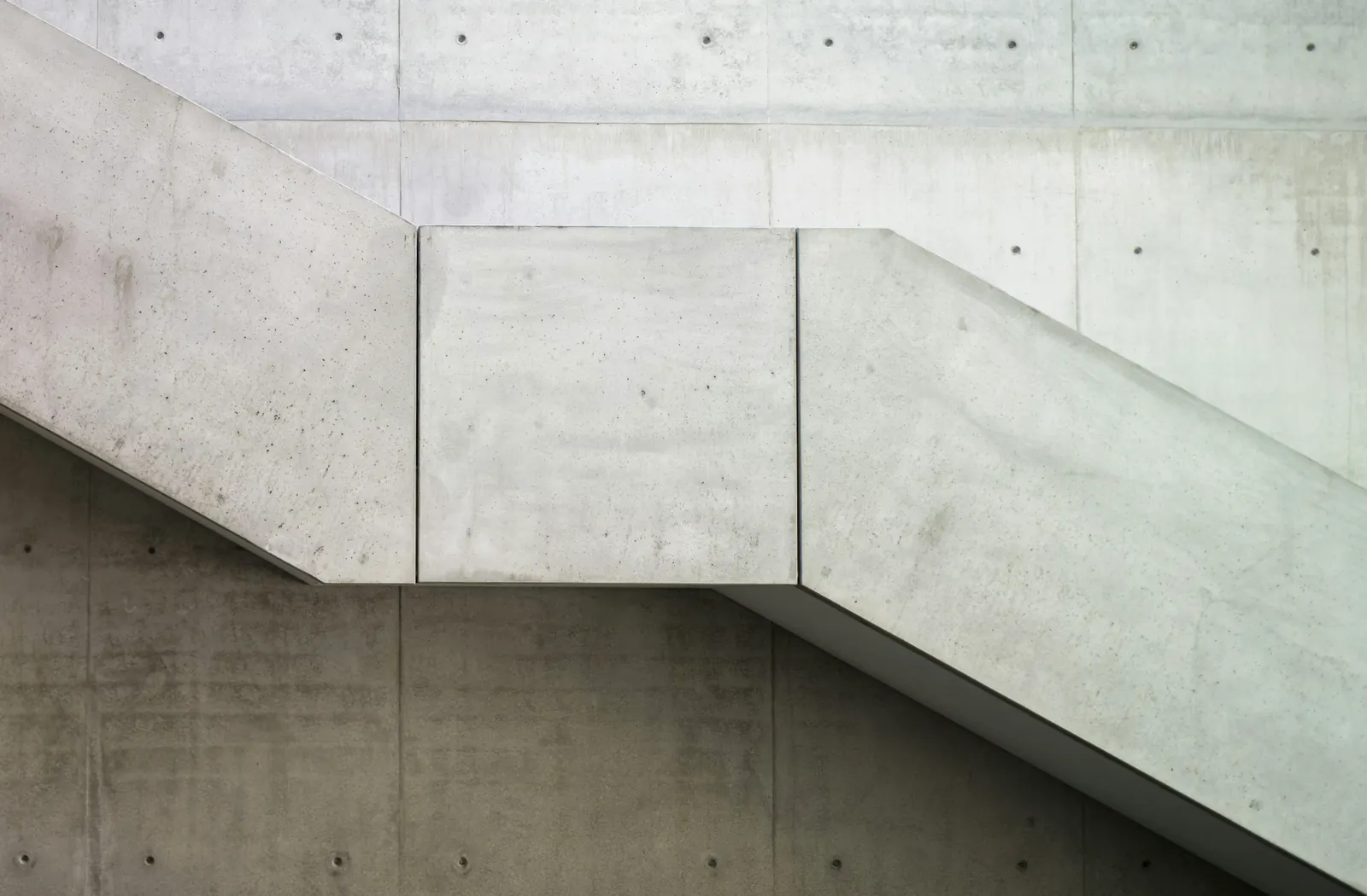 A concrete staircase against a bare concrete wall