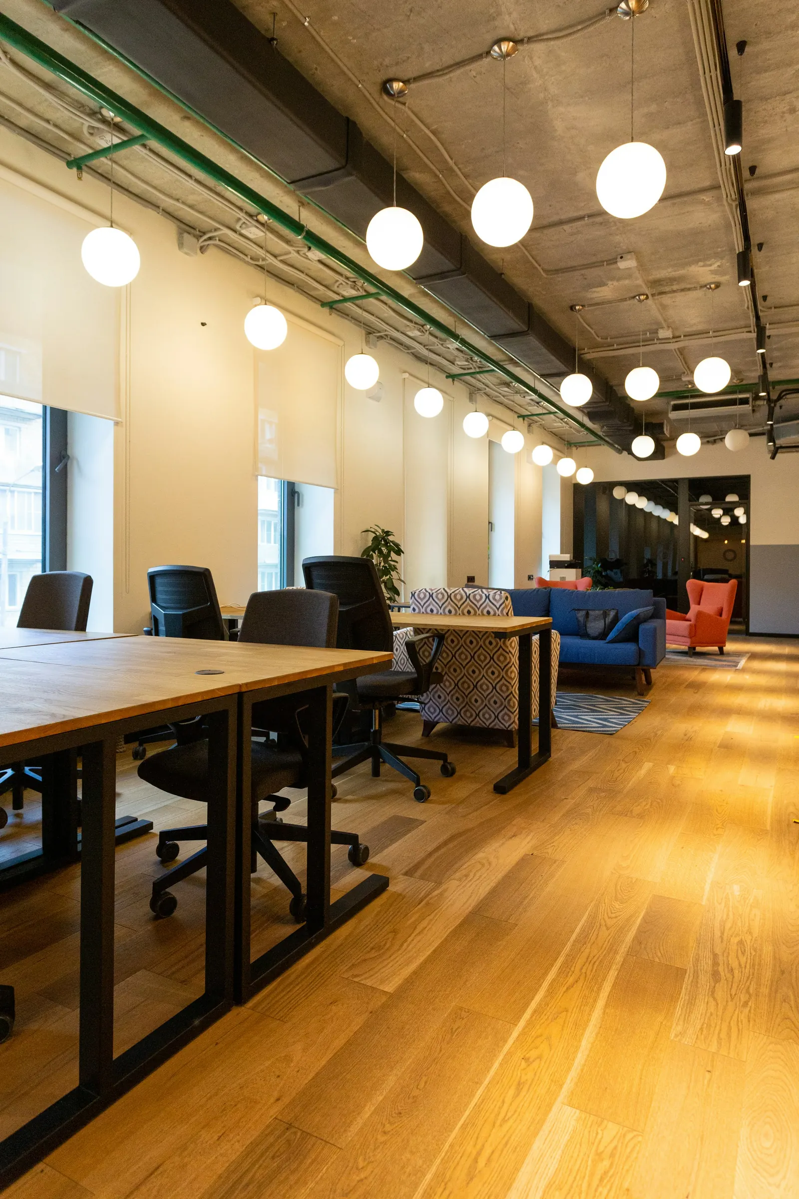 Coworking space with long wooden desks and pendant lights