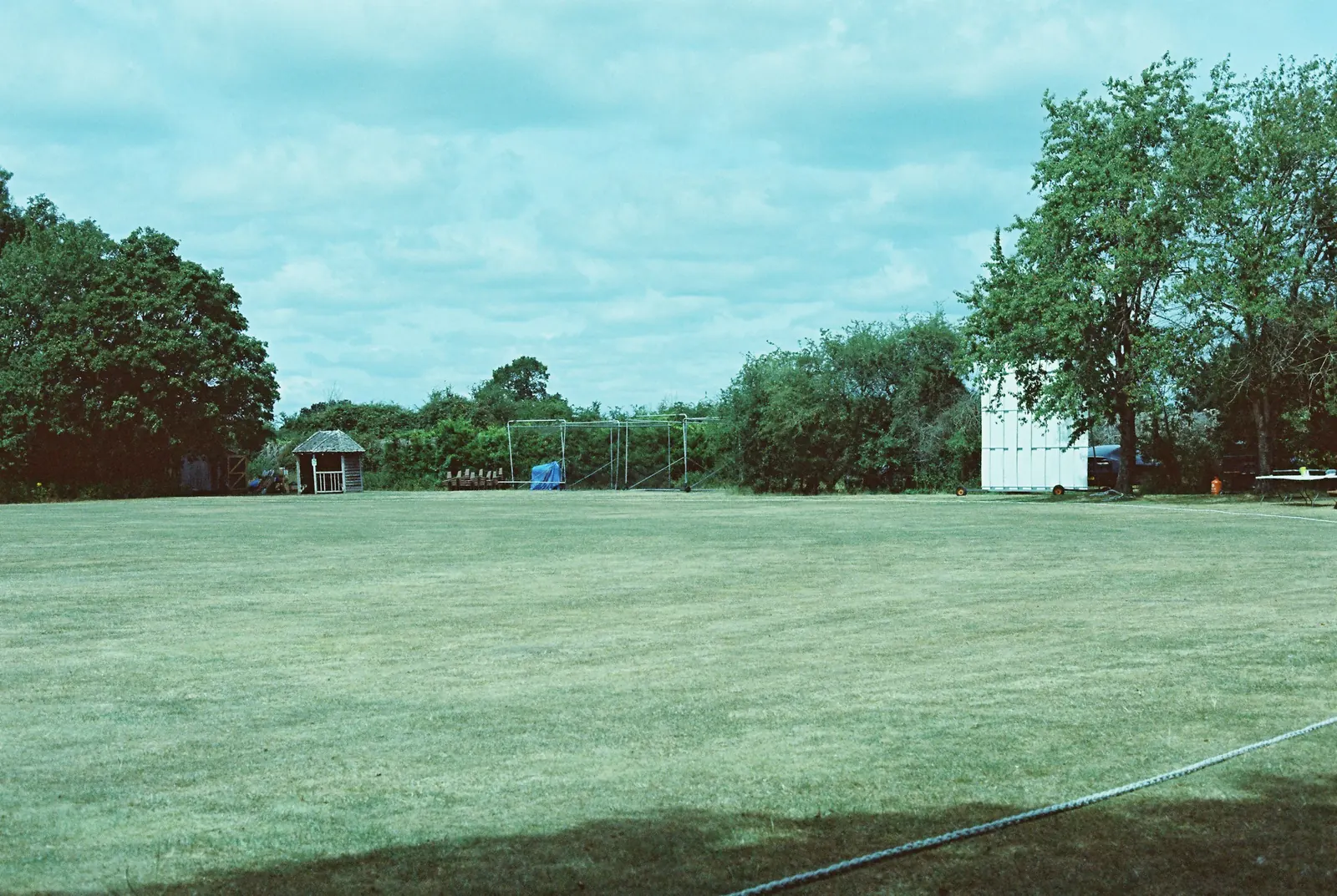 A cricket ground under a cloudy sky